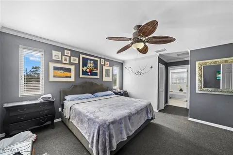 a bedroom with a bed next to a window and a chandelier