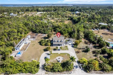 an aerial view of a house with a yard and lake view