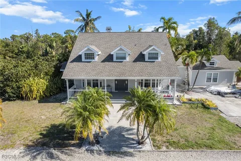 a front view of house with yard and trees in the background