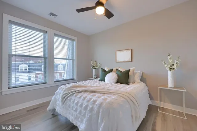 a large bed sitting in a bedroom next to a window and a chandelier