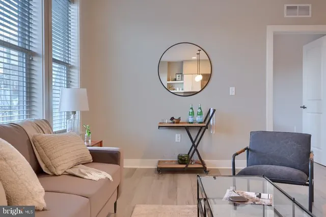 a living room with furniture a mirror and a table