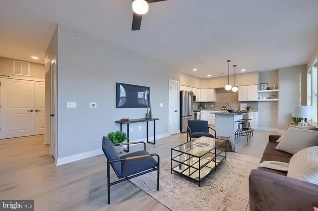 a living room with furniture and a wooden floor