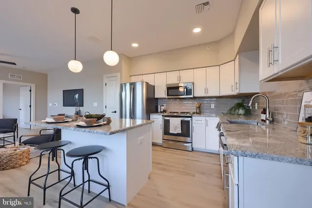 a kitchen with stainless steel appliances granite countertop a sink refrigerator stove microwave and cabinets