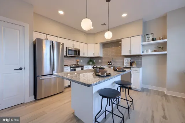 a kitchen with refrigerator cabinets and wooden floor