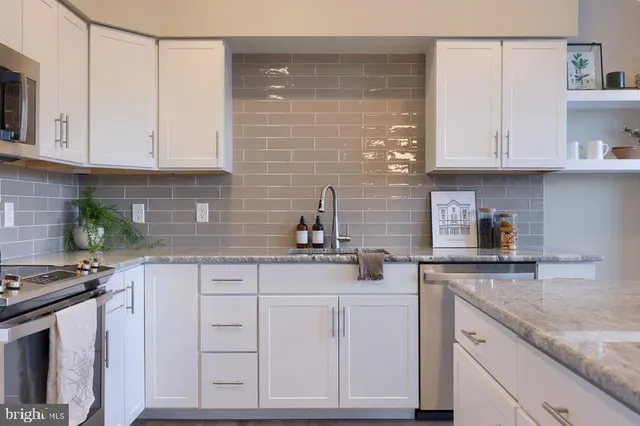 a kitchen with granite countertop white cabinets and white appliances