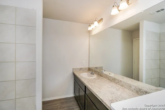 a bathroom with a granite countertop sink and a mirror