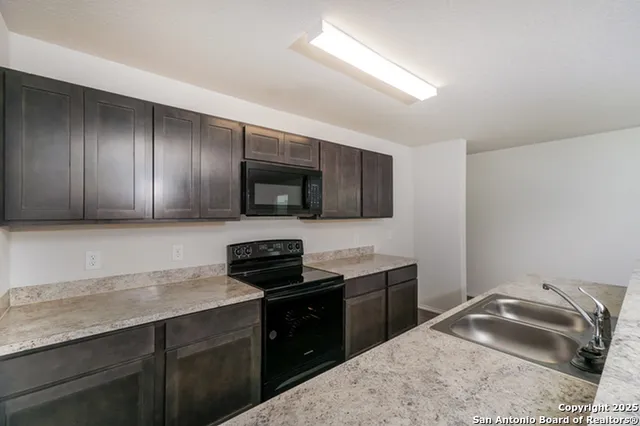 a kitchen with a sink stove and microwave