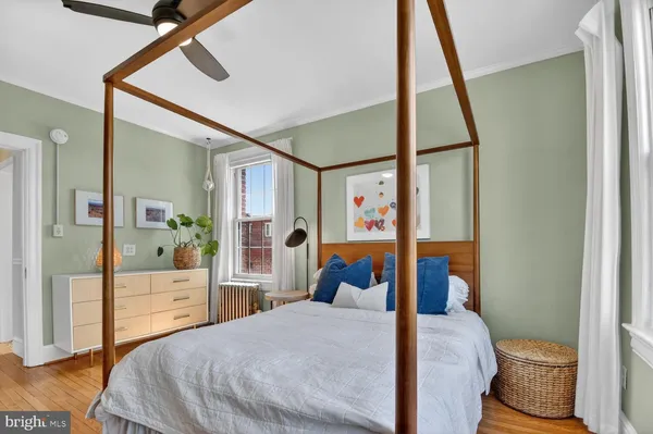 a bedroom with a bed and wooden floor