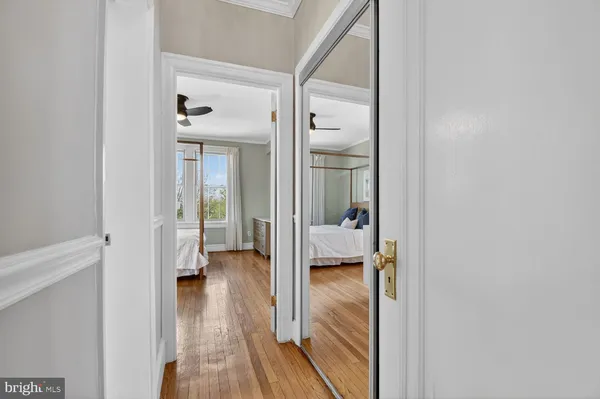 a view of a hallway with toilet and a livingroom view