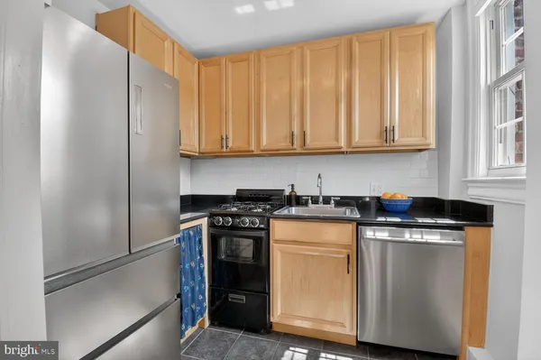a kitchen with stainless steel appliances granite countertop a stove a refrigerator and a microwave