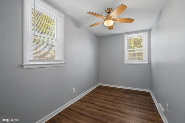 a view of an empty room with window and wooden floor