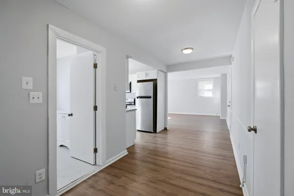 a view of a hallway with wooden floor and closet area