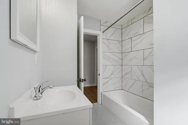 a bathroom with a sink and bathtub with shower
