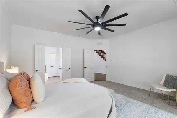 a bedroom with a large bed and a chandelier