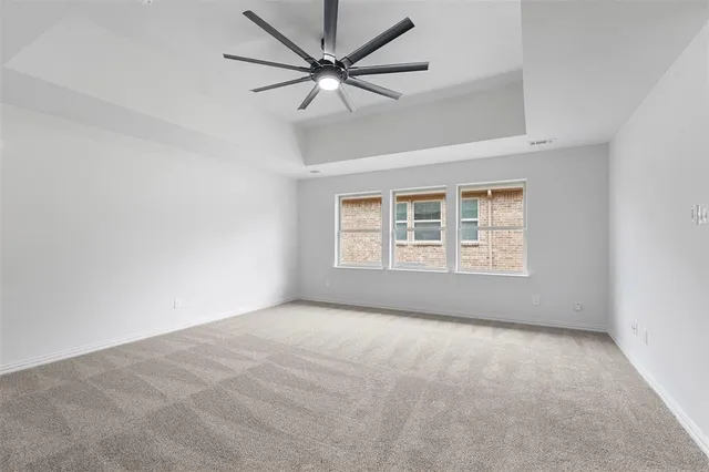 an empty room with a window and a ceiling fan