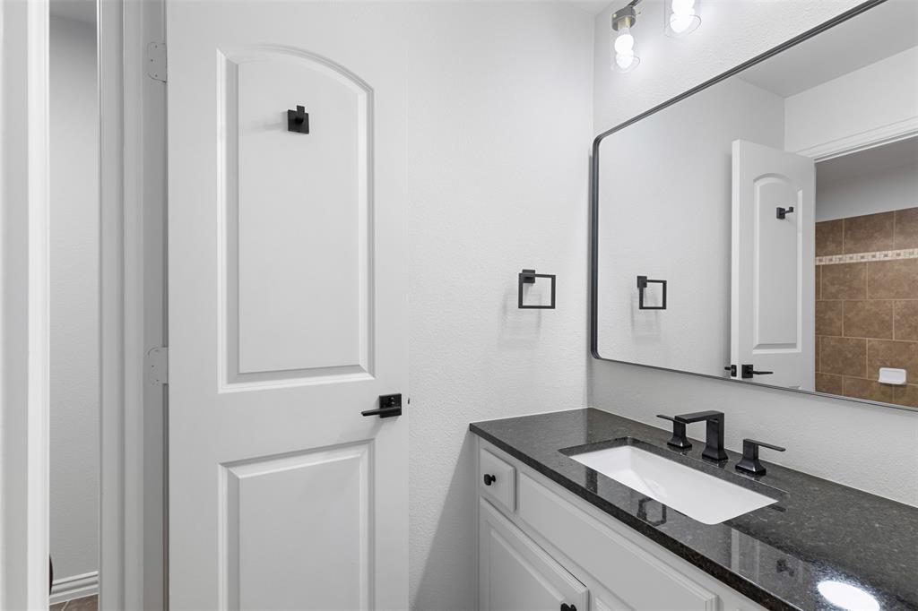 11984 Del Rio Drive Frisco, TX 75035 - Photo 26 of 38 a bathroom with a granite countertop sink and a mirror