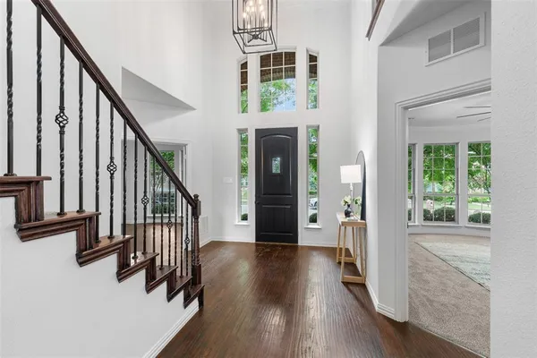a view of a hallway with wooden floor and staircase