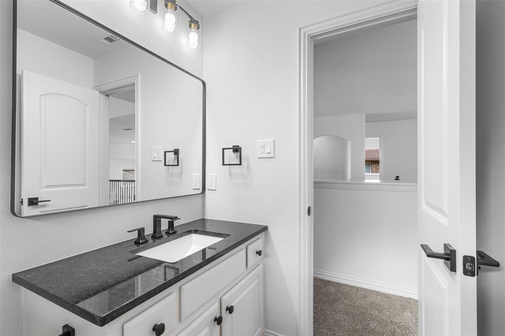 11984 Del Rio Drive Frisco, TX 75035 - Photo 31 of 38 a bathroom with a granite countertop sink and a mirror