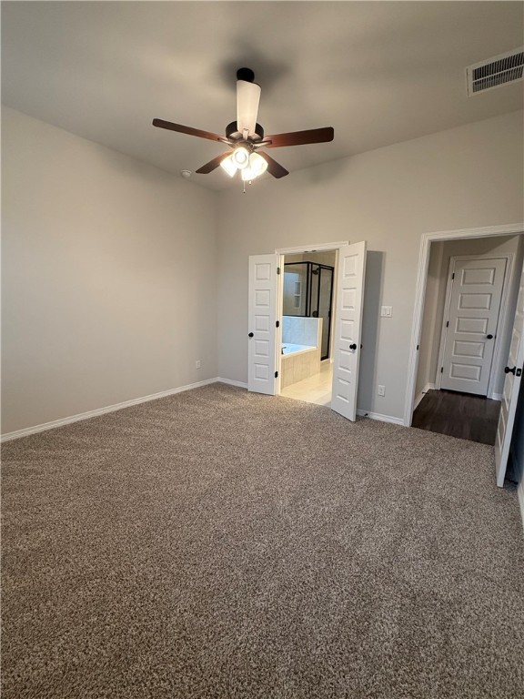 6308 Raleigh Drive College Station, TX 77845 - Photo 6 of 19 Unfurnished bedroom featuring dark colored carpet, ensuite bathroom, and ceiling fan