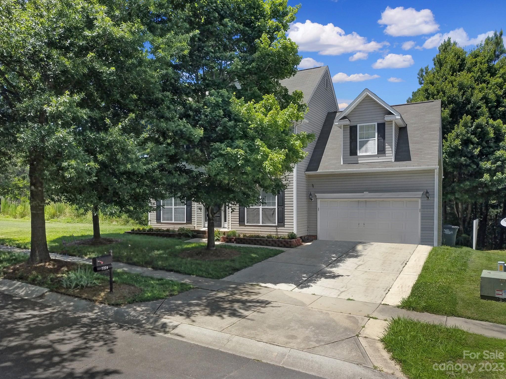 7224 Cascading Pines Drive Tega Cay, SC 29708 - Photo 1 of 36 a front view of a house with a garden and trees