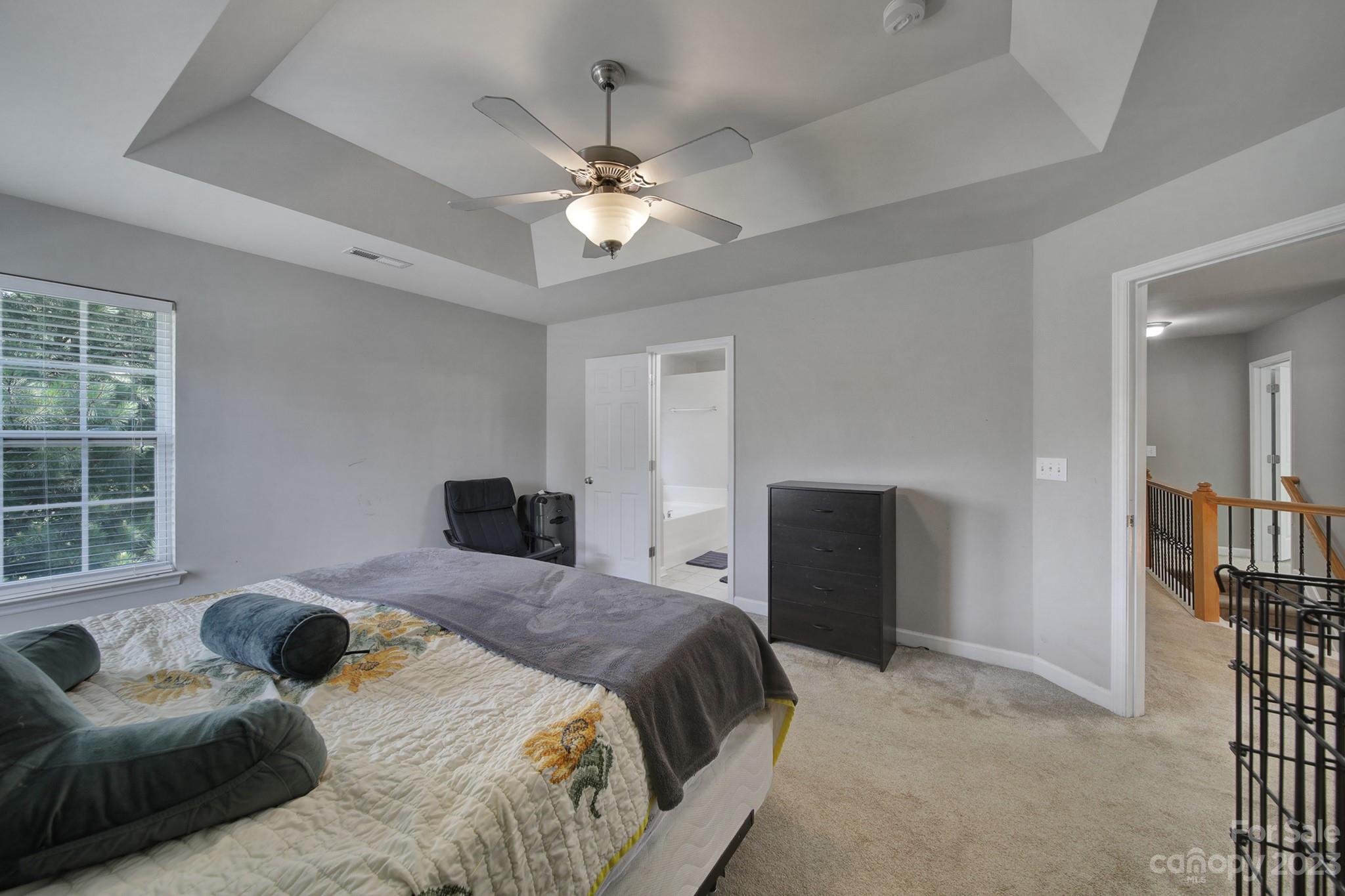 7224 Cascading Pines Drive Tega Cay, SC 29708 - Photo 19 of 36 a bedroom with a bed and a chandelier