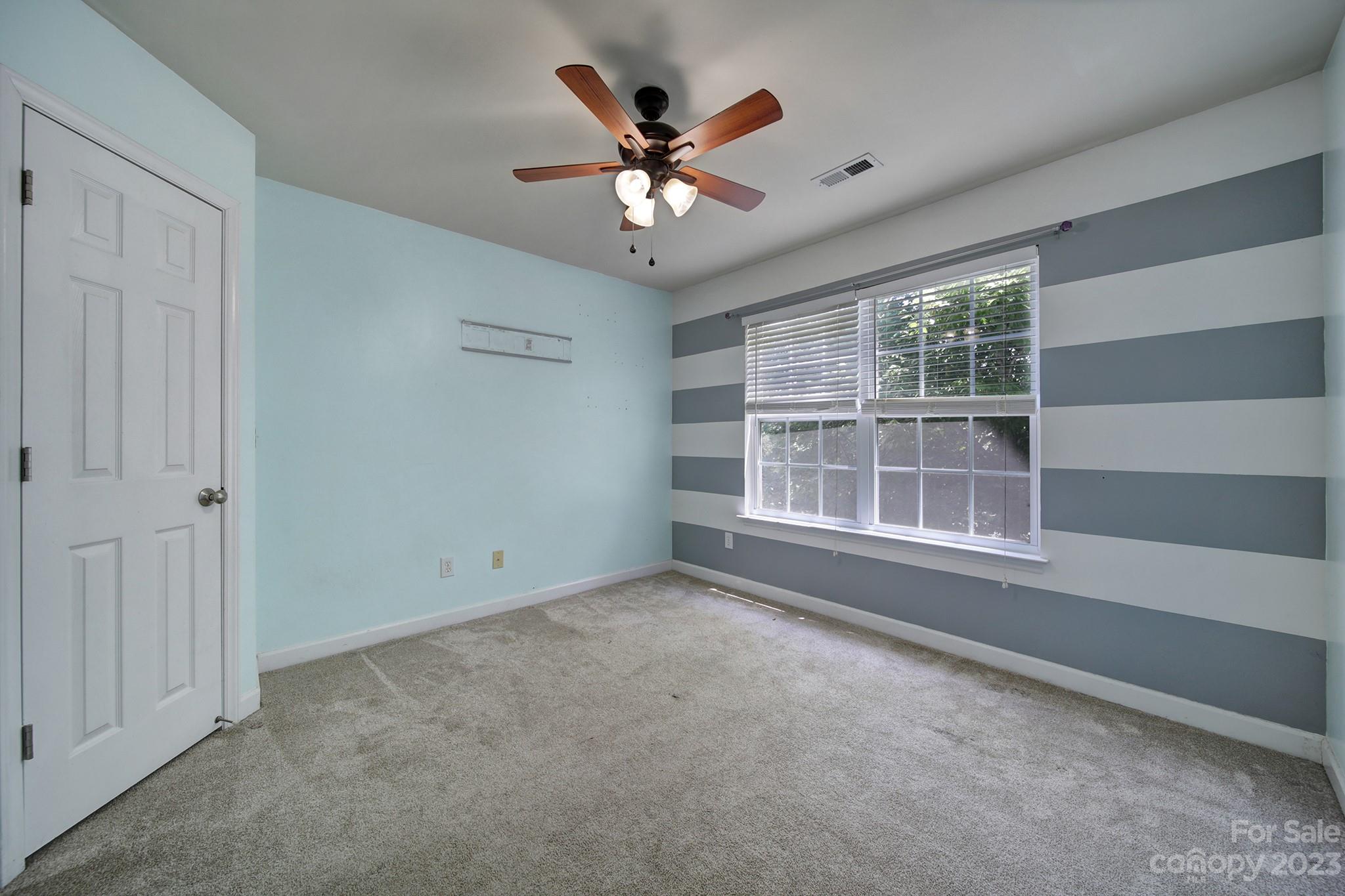 7224 Cascading Pines Drive Tega Cay, SC 29708 - Photo 22 of 36 an empty room with ceiling fan and window
