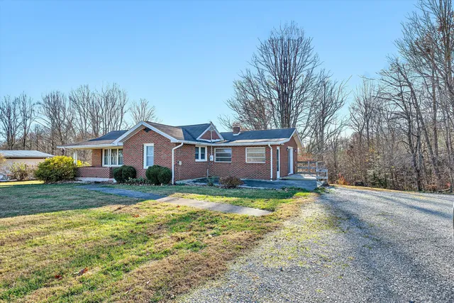 a view of a yard in front of a house with large trees