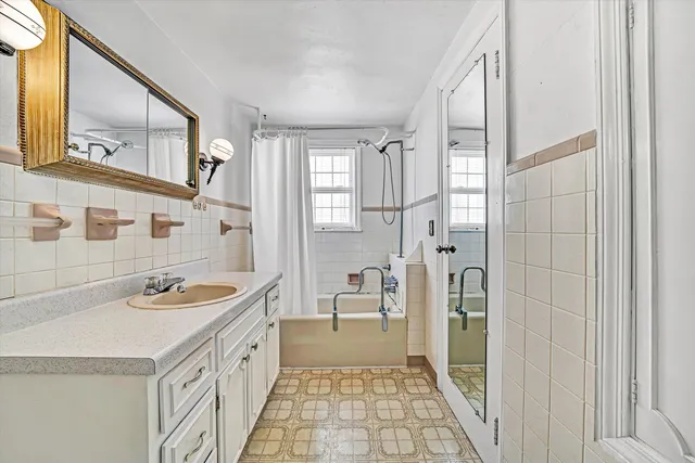 a bathroom with a granite countertop sink a mirror a vanity and a shower