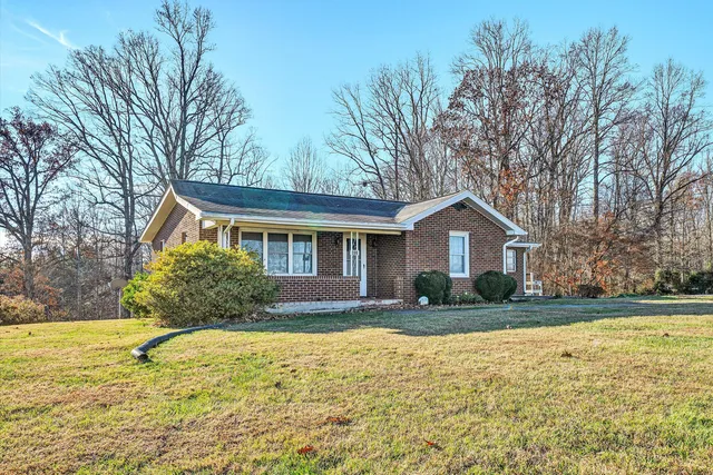 a front view of house with yard and trees around