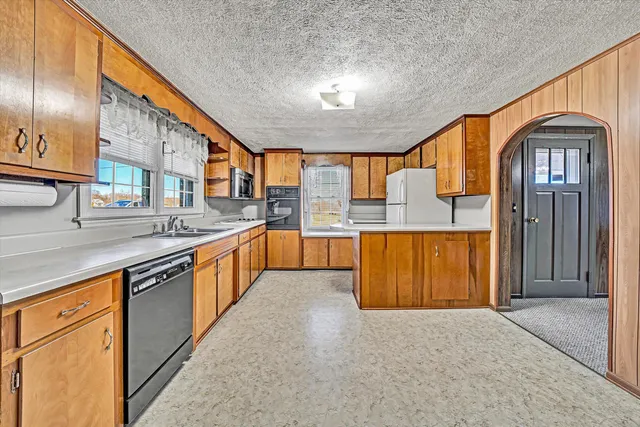 a large kitchen with stainless steel appliances granite countertop a granite counter tops and a stove