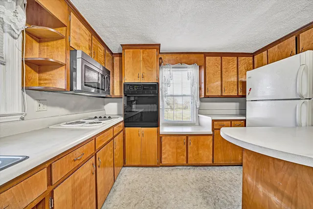 a kitchen with stainless steel appliances granite countertop a stove a sink and a refrigerator
