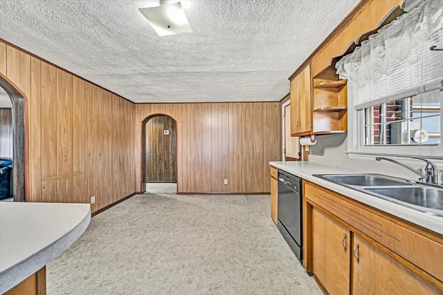 a view of a kitchen with granite countertop cabinets stainless steel appliances a sink and a large window