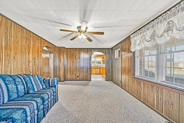 a living room with a large window and a chandelier