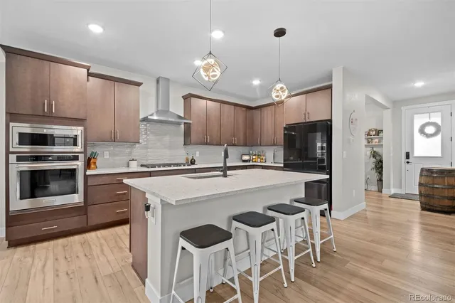 a kitchen with stainless steel appliances a stove a sink island and a refrigerator