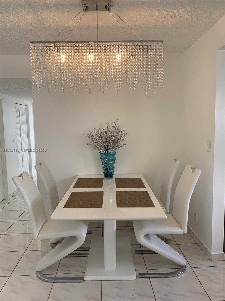 17021 North Bay Road, Unit 907 Sunny Isles Beach, FL 33160 - Photo 5 of 19 a view of a dining room with furniture and wooden floor