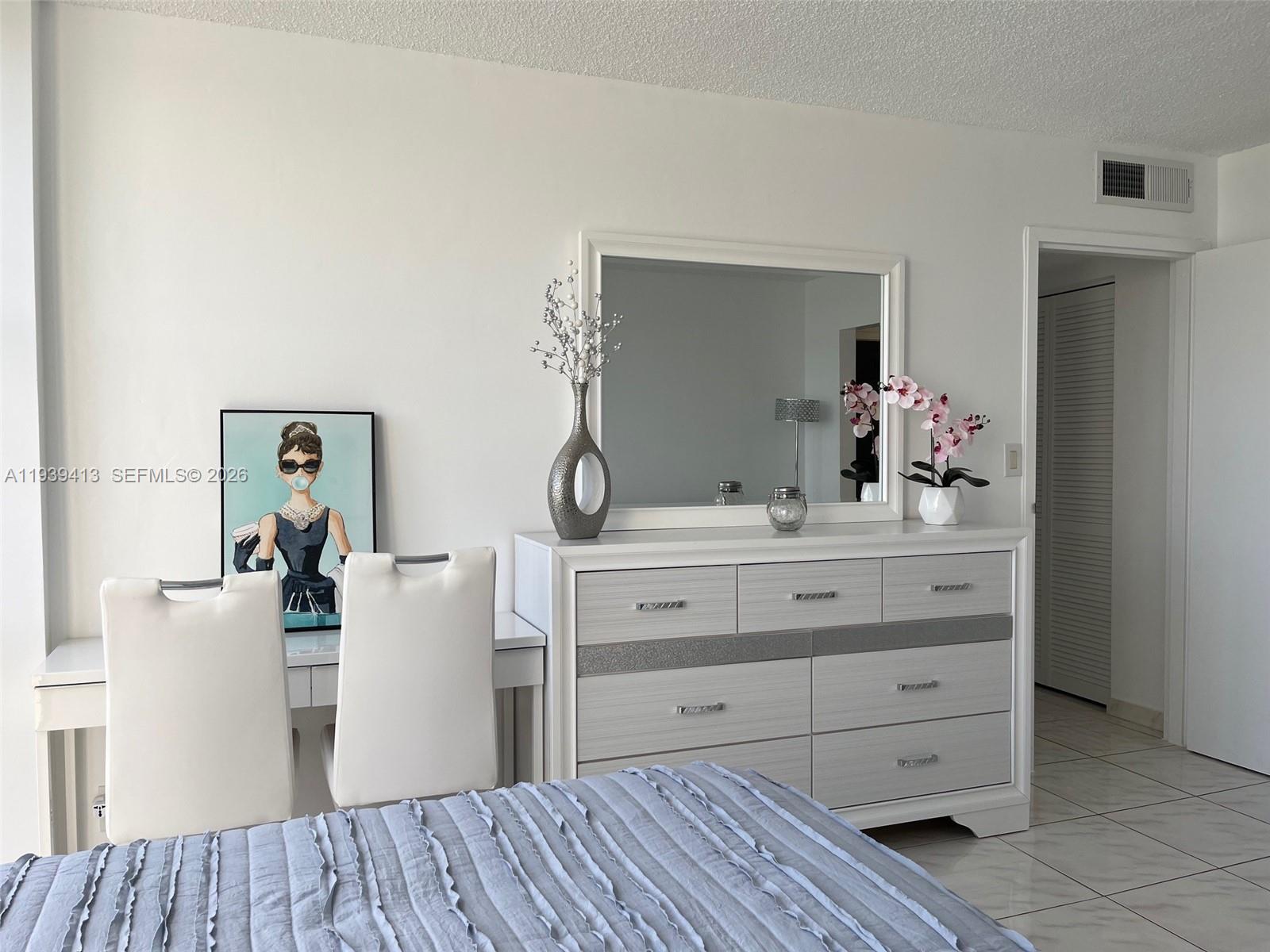 17021 North Bay Road, Unit 907 Sunny Isles Beach, FL 33160 - Photo 6 of 19 a room with a dresser and a mirror
