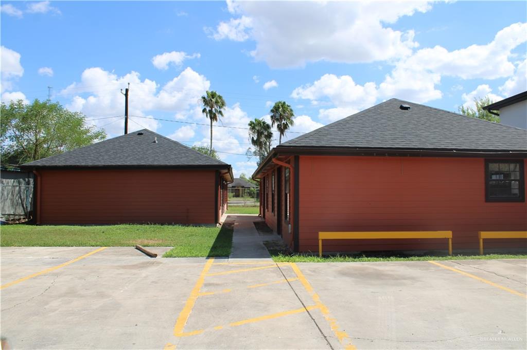 View of home's exterior with a shingled roof and uncovered parking