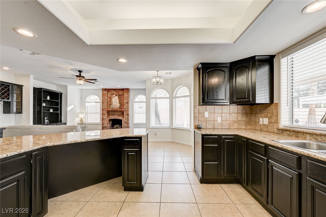 2955 El Camino Road Las Vegas, NV 89146 - Photo 98 of 99 Kitchen featuring open floor plan, recessed lighting, a fireplace, a chandelier, and light tile patterned floors