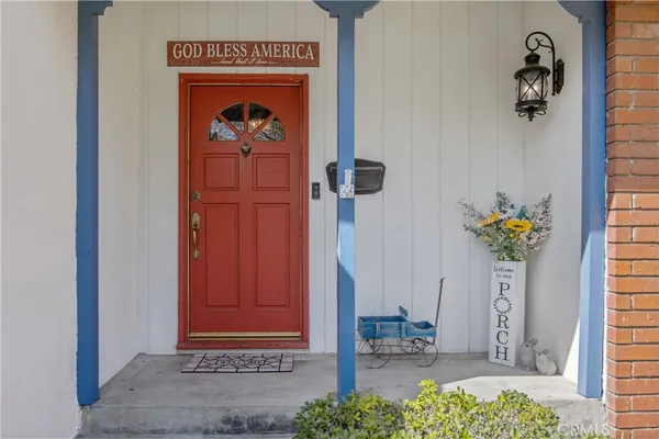 a vase of flowers sitting on a floor in front of a door