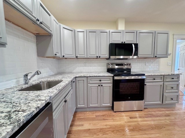 a kitchen with stainless steel appliances granite countertop a sink dishwasher stove and oven with granite countertops