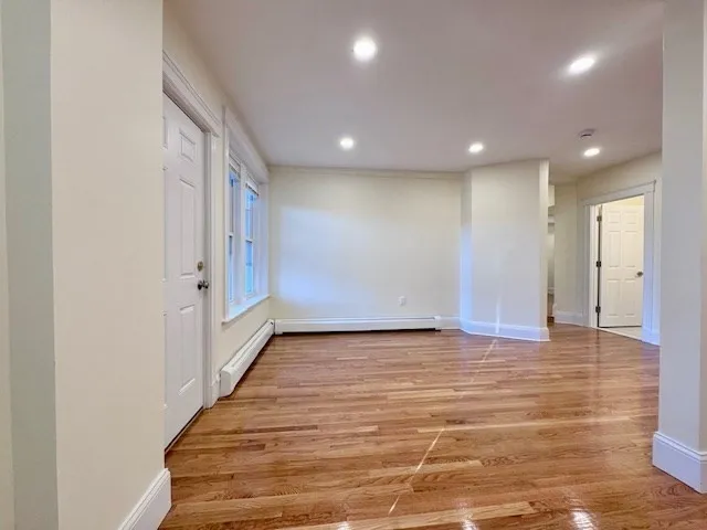 a view of an empty room with wooden floor