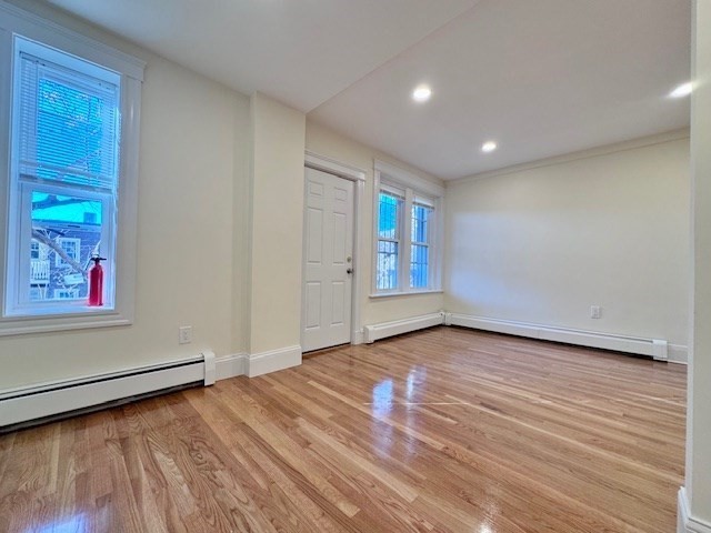 56 Cummings Road, Unit B Boston, MA 02135 - Photo 6 of 13 a view of an empty room with wooden floor and a window