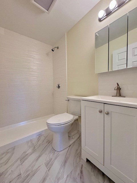 56 Cummings Road, Unit B Boston, MA 02135 - Photo 9 of 13 a bathroom with a toilet a sink a vanity and mirror