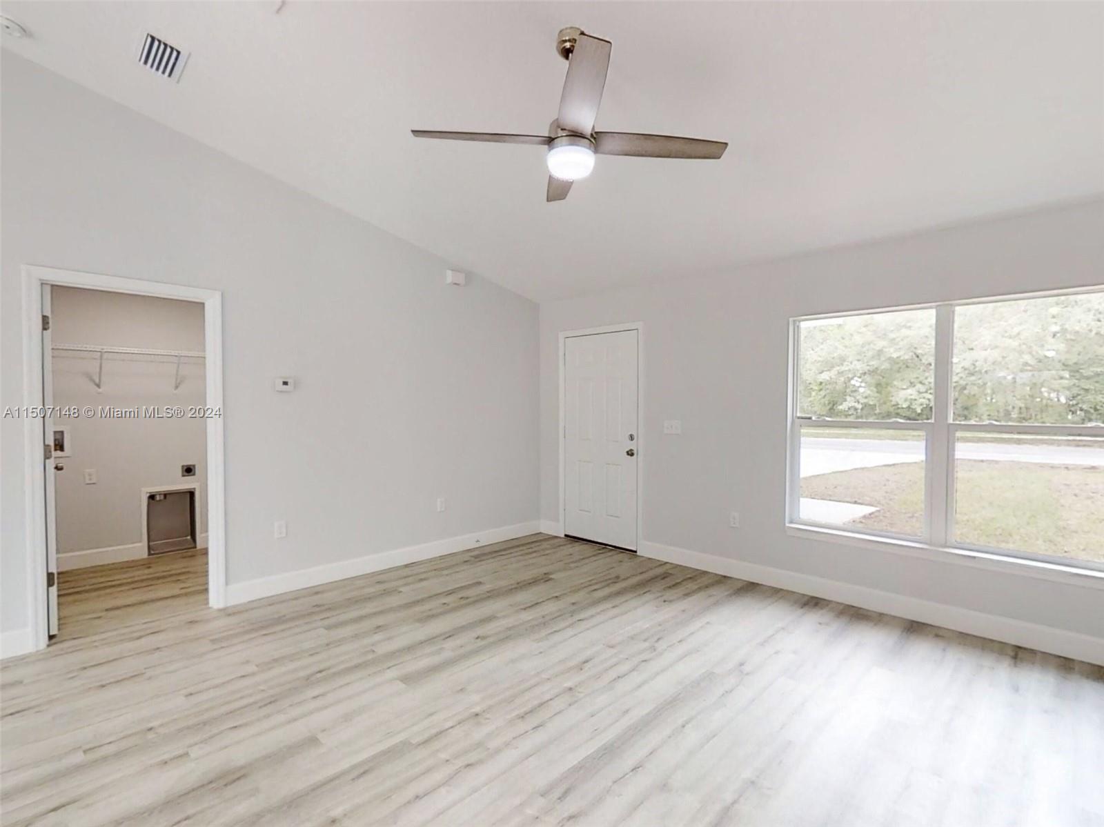 14512 Southwest 25th Lane Ocala, FL 34481 - Photo 13 of 30 an empty room with wooden floor fan and windows