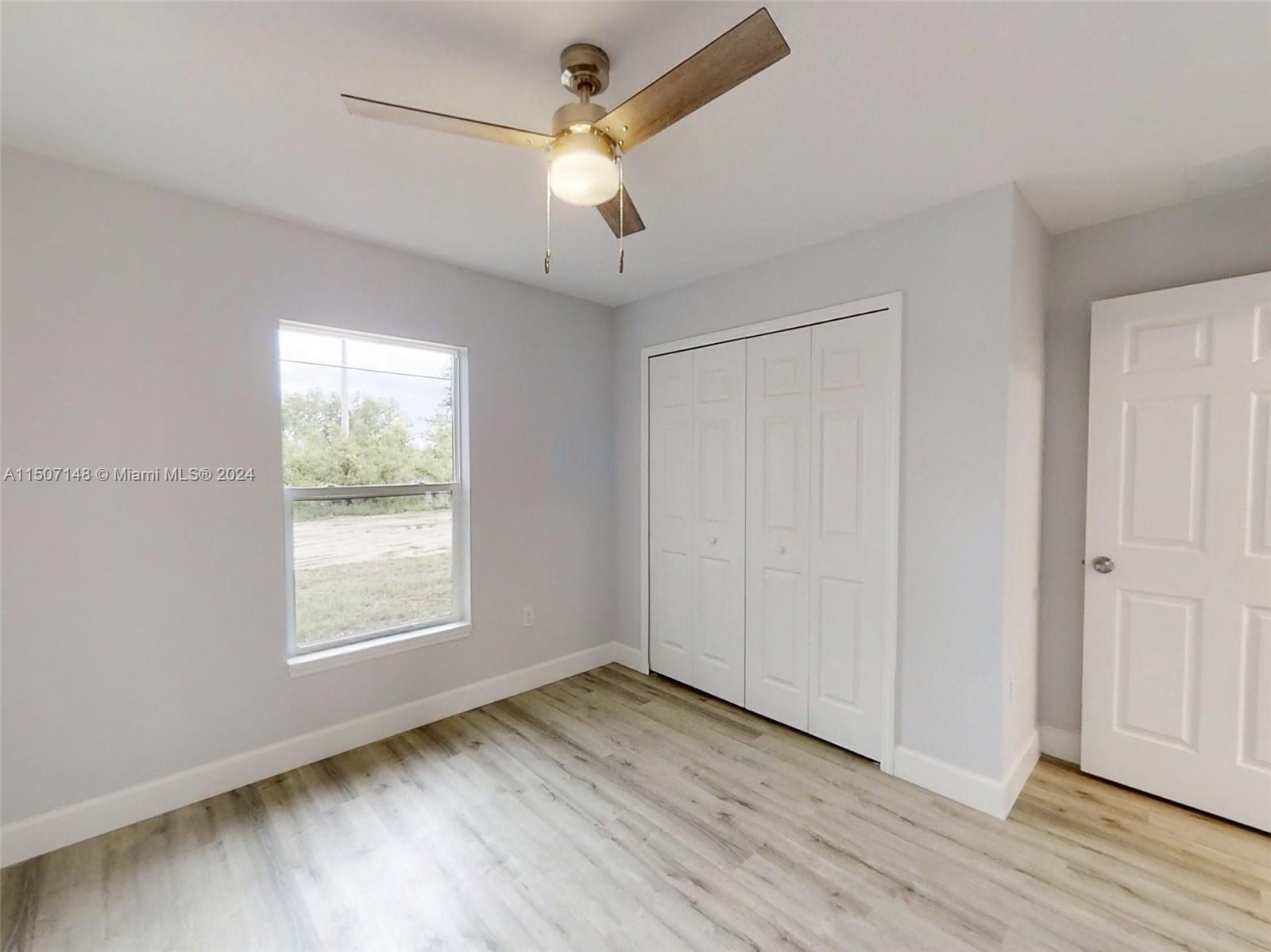 14512 Southwest 25th Lane Ocala, FL 34481 - Photo 18 of 30 an empty room with wooden floor chandelier fan and windows