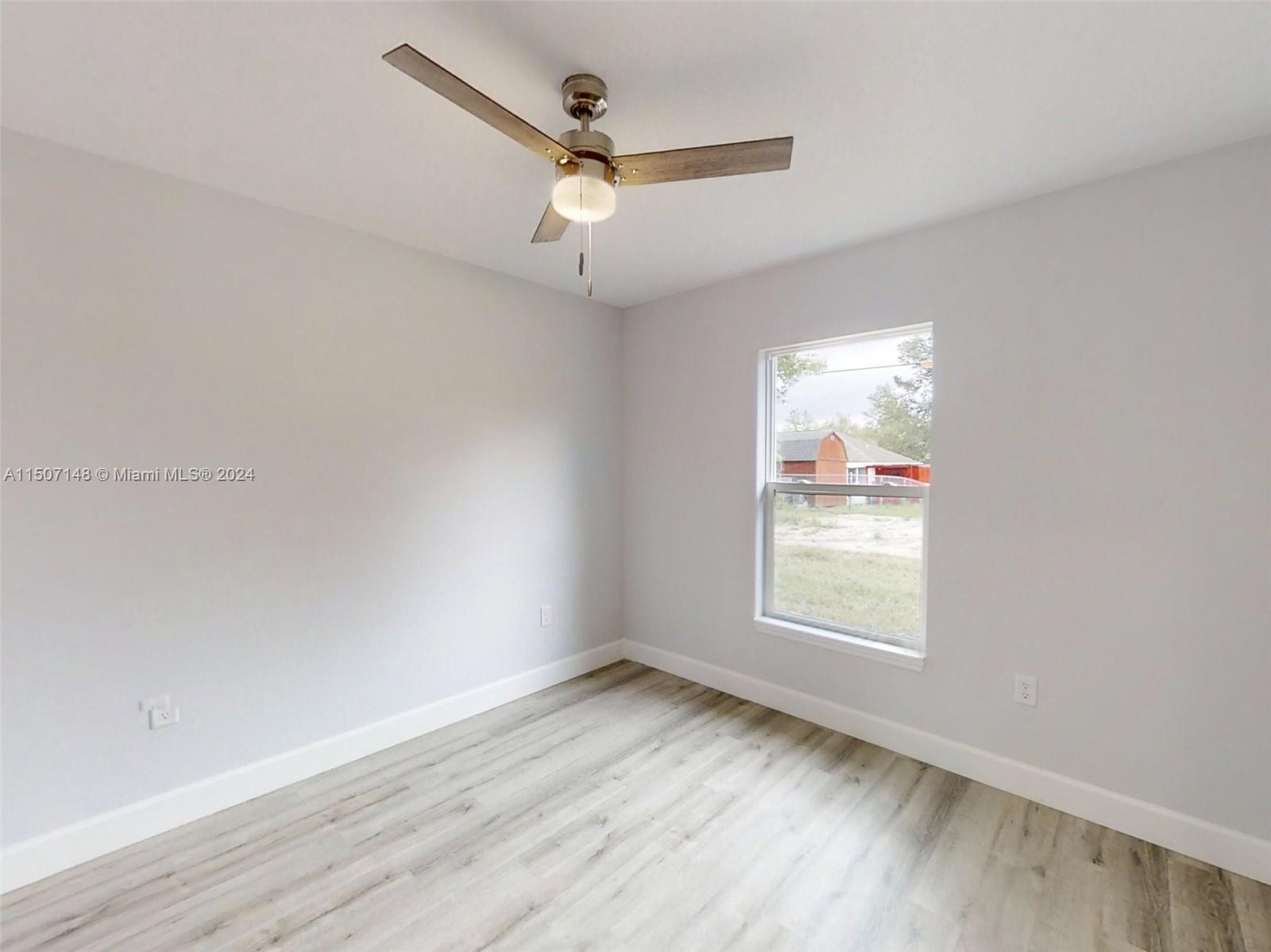 14512 Southwest 25th Lane Ocala, FL 34481 - Photo 19 of 30 an empty room with wooden floor ceiling fan and windows