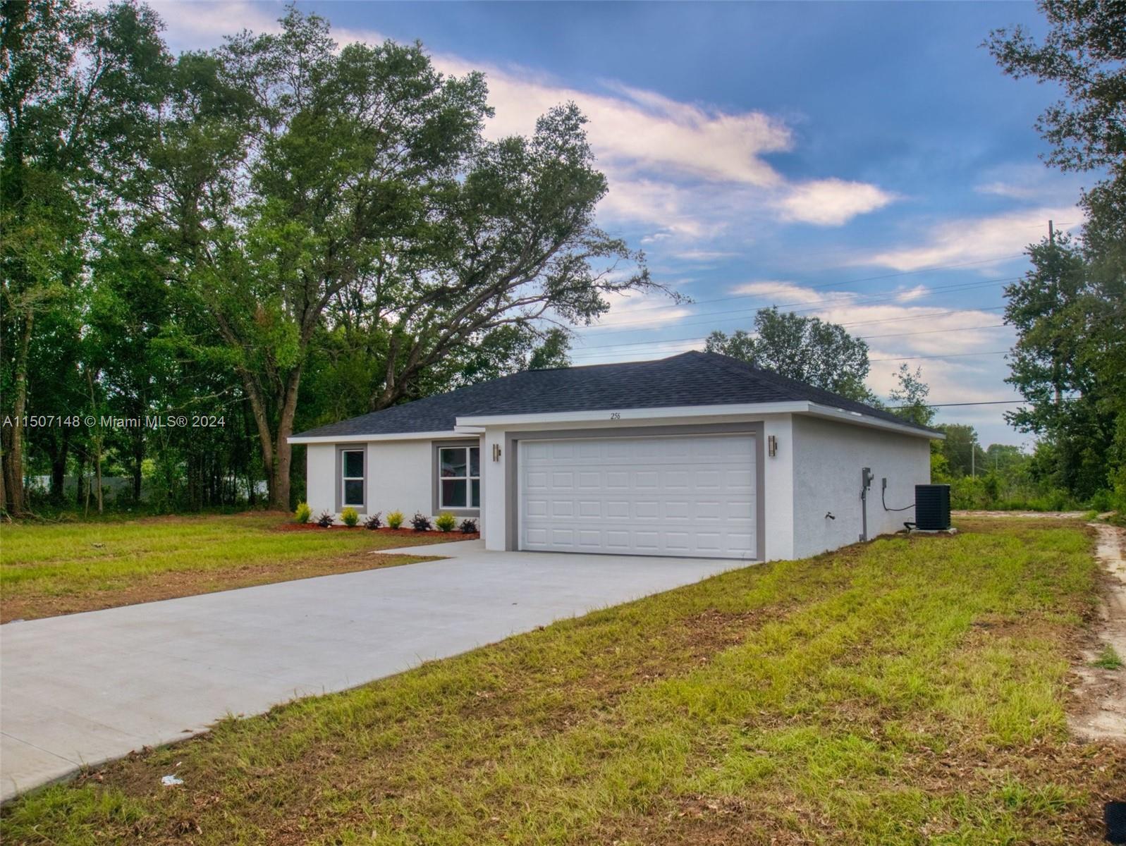 14512 Southwest 25th Lane Ocala, FL 34481 - Photo 2 of 30 a front view of a house with yard and trees