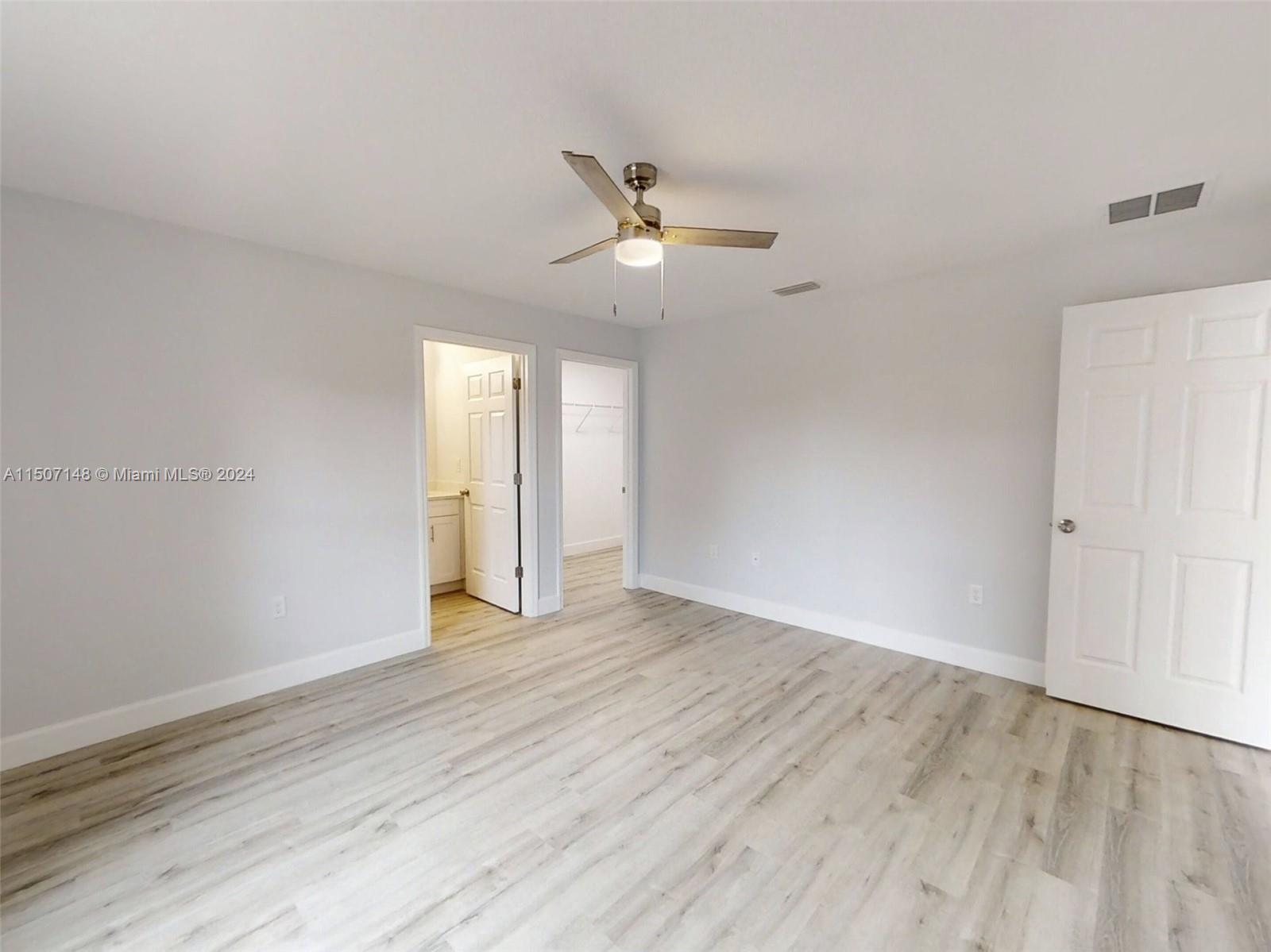 14512 Southwest 25th Lane Ocala, FL 34481 - Photo 22 of 30 a view of an empty room with wooden floor and a ceiling fan