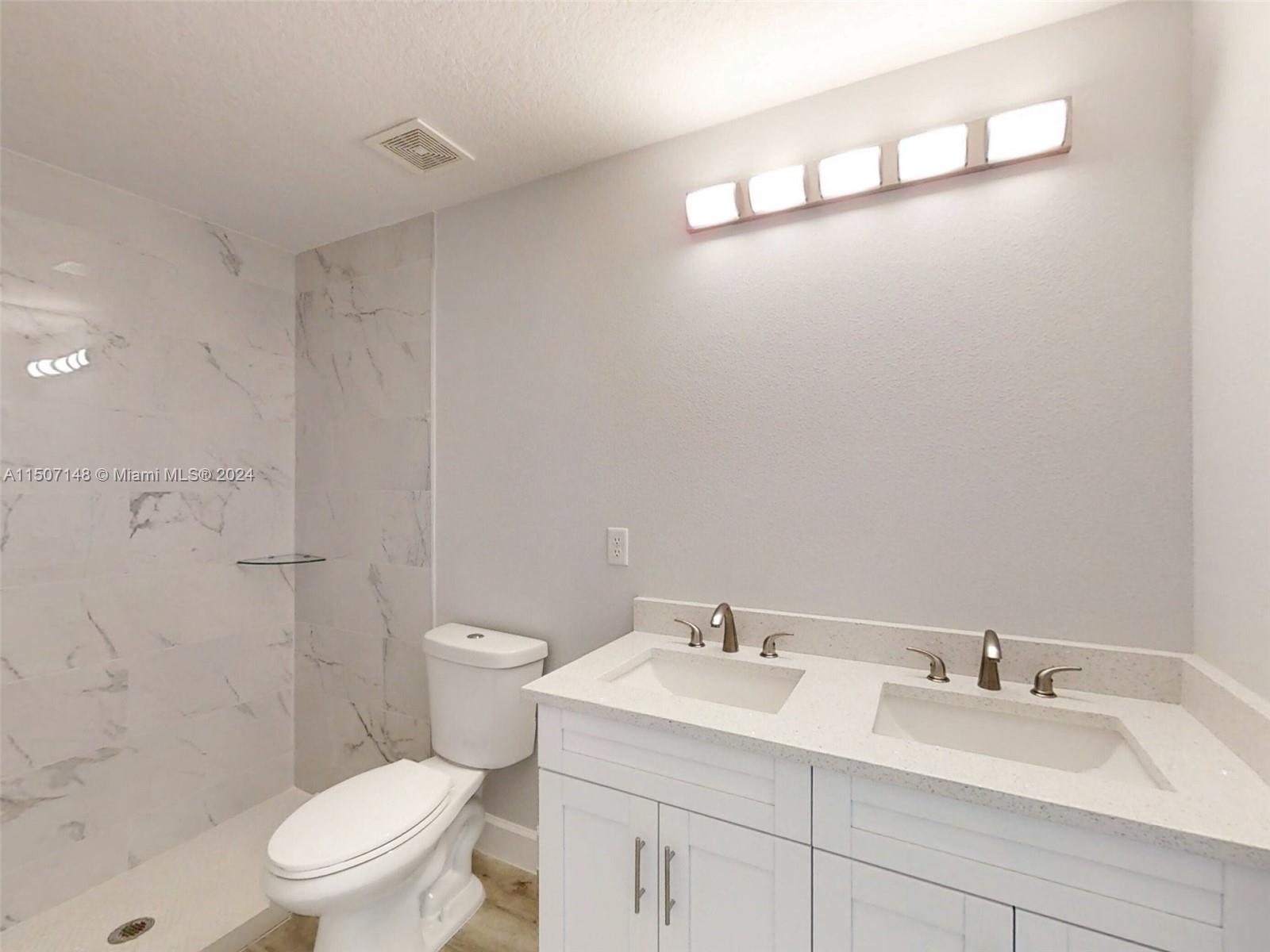 14512 Southwest 25th Lane Ocala, FL 34481 - Photo 24 of 30 a bathroom with a granite countertop sink a toilet and a mirror
