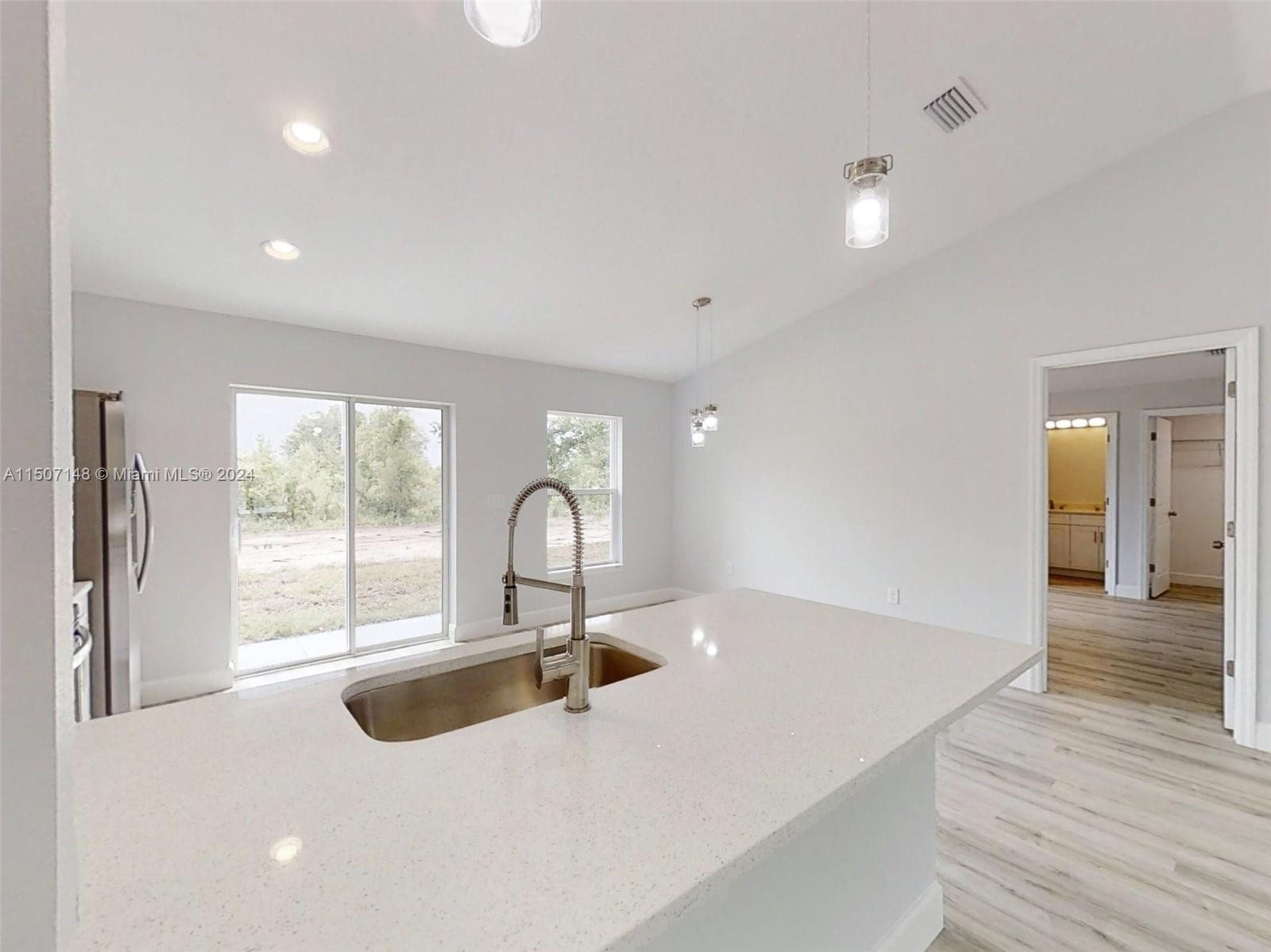 14512 Southwest 25th Lane Ocala, FL 34481 - Photo 9 of 30 a kitchen with kitchen island a sink appliances and a large window